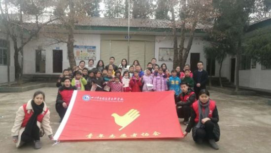 图为社会实践团队与当地学生合影留念。 薛莹莹 摄